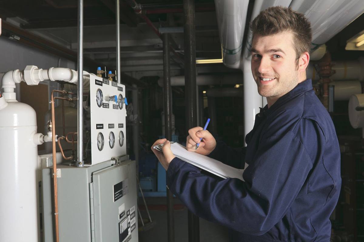 Oil tank technician reviewing heating equipment in a Levittown NY basement