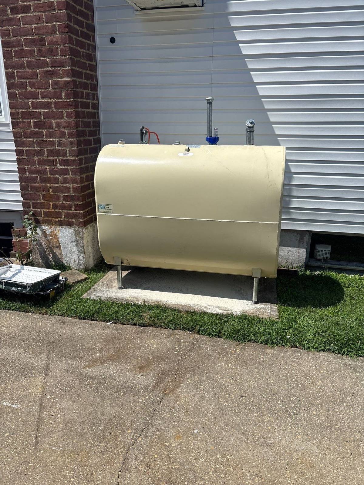 Old above-ground heating oil tank awaiting removal outside a Long Island home